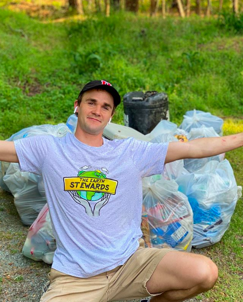 Daniel Toben poses with trash collected from plogging, an activity that is a combination of jogging and picking up roadside litter.