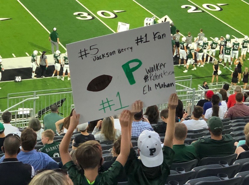 Holding+up+a+sign+for+his+Flight+Crew+buddy%2C+second+grader+Eli+Mahan+supports+varsity+senior+football+player+Jackson+Berry+at+a+home+football+game.+Government+teacher+Irish+Mahan%2C+Eli+Mahans+mom%2C+said+that+her+son+always+makes+sure+to+wear+his+Berry+%25235+T-shirt+when+he+goes+to+games.+My+son+loves+being+a+part+of+this+program%2C+Mahan+said.+Jackson+%28Berry%29+has+written+to+Eli+every+single+week+of+his+football+season%2C+offering+encouragement+and+advice.