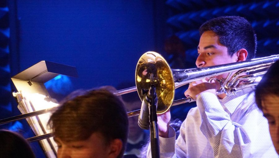 Senior Jacob Martinez stands to perform a trombone solo at downtown Parker Jazz Club alongside fellow McCallum Jazz Ensemble musicians. In addition to earning TMEA All-State recognition in the concert band competition, Martinez earned a state spot in jazz as of last semester.