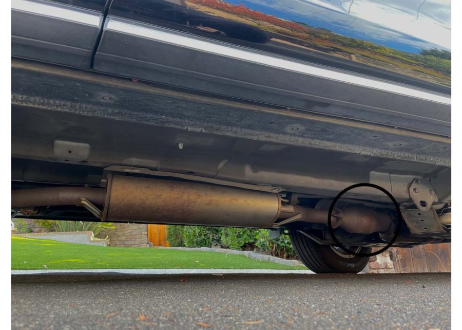 In a car, the catalytic converter sits towards the front of the car, in front of the muffler. 