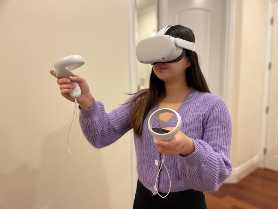 Eighth+grader+Tiffany+Zhu+uses+a+virtual+reality+%28VR%29+headset+and%0Ahandheld+devices.+VR+lets+consumers+play+immersive+games+and+visit+fictional+spaces.