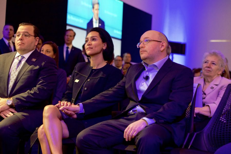 Jason Rezaian listens to a speech while holding his wife’s hand, his brother on her other side.