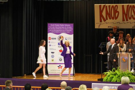First Lady Jill Biden waves to Knob Noster students and teachers, distinguished guests from the community and JROTC students as she steps onstage.