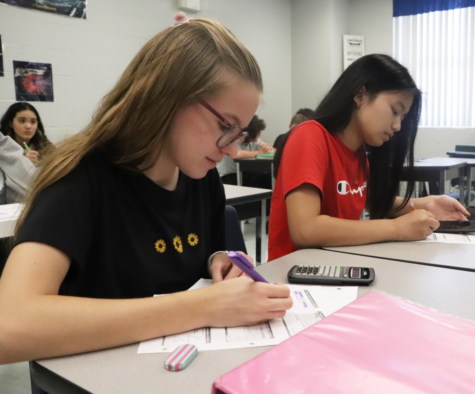 Freshmen Annabelle Etz (left) and Josephine Lim (right) take notes in Geometry Honors. Two Geometry textbooks were rejected due to the discussion of banned topics.