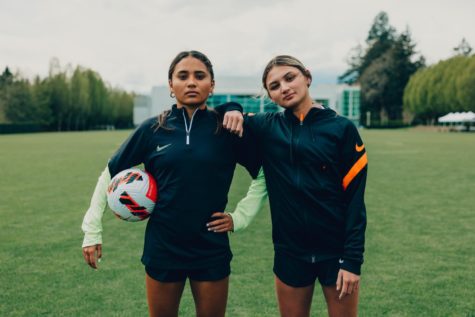 Alyssa Thompson 23 and Gisele Thompson 24 pose with a soccer ball wearing Nike gear. The sisters are the first high school athletes in history to sign an NIL deal with Nike. 