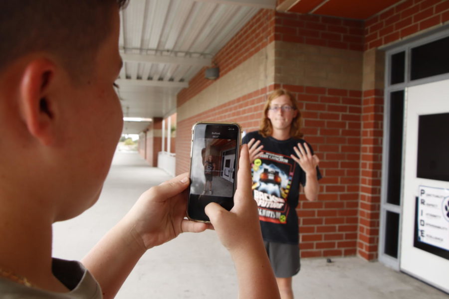 Junior Dylan Severance takes a BeReal photo for junior William Carr. As the photo is taken, both the front and back cameras are used to capture both students in the post. 
