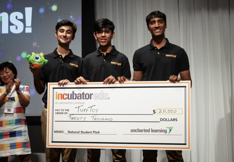 Seniors Zubin Khera, Arin Jain and Rohan Gorti hold up a check of 0,000 written to TuffToy after winning the National Pitch Competition in Chicago in July. The three founded TuffToy in their junior year to sell customizable and durable dog toys.