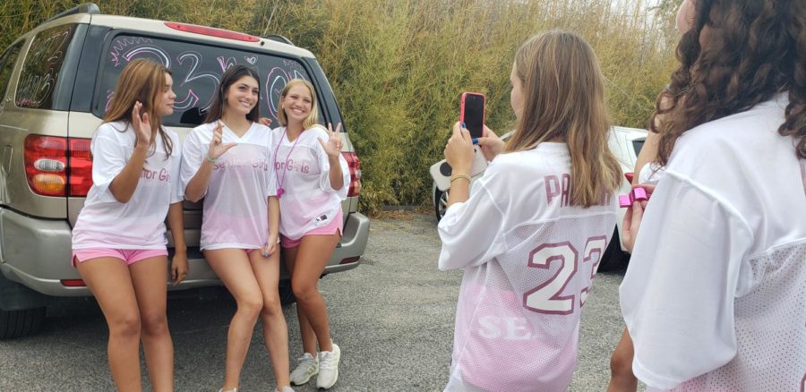 SENIOR SEASON: Decked out in their jerseys, senior Parker Mitchell takes a photo of senior Sophia Kramer and friends before the first day of school in the senior parking lot. The night before, the class of ‘23 decorated their cars to show their senior pride going into their last year of high school. “It’s tradition for seniors to come and take [pictures] the morning before the first day of school,” Kramer said. “Being able to share that memory together is definitely bittersweet. I’m super excited for this year but I am anticipating all the lasts.” Reporting by Alice Scott.