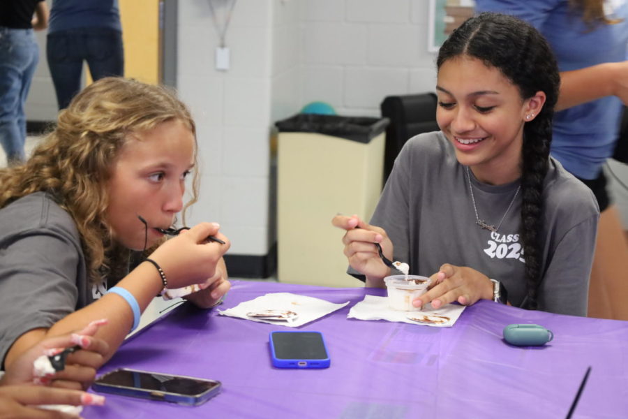 Sophomores Gabriella Heina and Angelina Acero enjoy some ice cream while playing a word game during the Best Buddies ice cream social on Aug. 26. Best Buddies members like Heina and Acero are partnered up with an ESE student as a buddy throughout the year. Activities include eating lunch with them, meeting them during break and participating in the Best Buddies friendship walk, a national fundraiser in April. 
