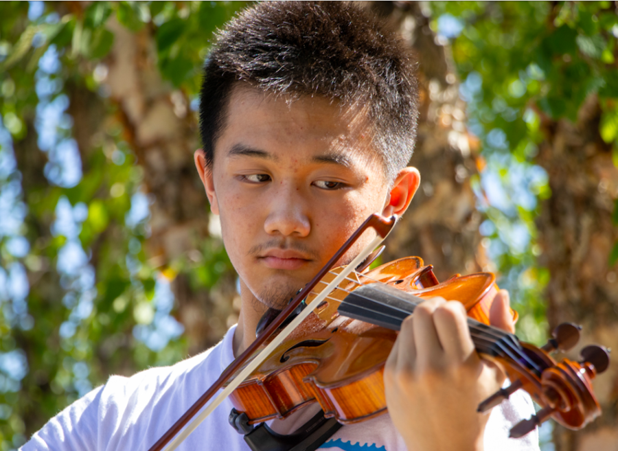 Freshman Bobby Guo plays his violin after school, Sept. 12. “I might as well practice and make use of that time to do something productive instead of waiting there and waste time,” Guo said. 