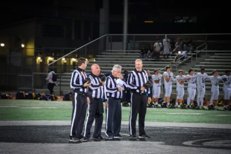 Referees line up for the national anthem during Burlingame’s varsity football game against Menlo School on Thursday, Oct. 27.