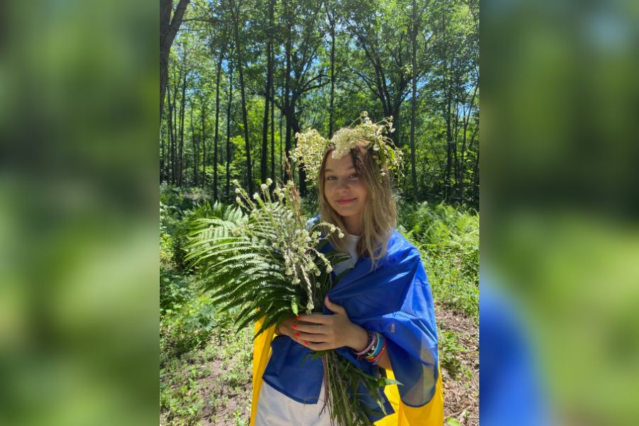 Wrapped in the Ukrainian flag, freshman Leeza Nozdrachova holds plants and flowers for Ivana Kupala, a Slavic holiday celebrating he summer solstice.