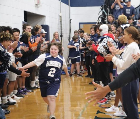 Sophomore Isabella Baker runs down the tunnel of football players and cheerleaders to play in the tournament. Unified basketball played against Turner Ashby, Spotswood and East Rockingham high schools Oct. 20.