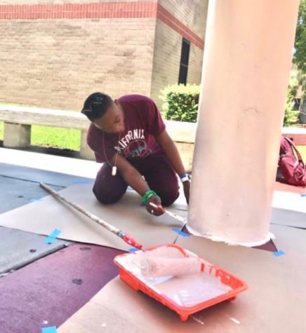 Junior Uriah Williams works diligently to paint for community service.