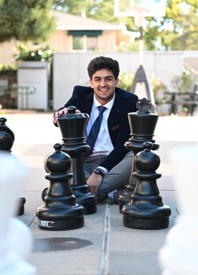 Vyom+Vidyarthi+%2810%29+sits+behind+the+king+and+queen+chess+pieces+at+the+large+chessboard+behind+Dobbins+Hall.+His+current+standard+rating+stands+at+2426.