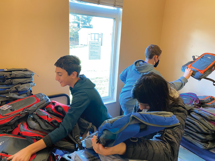 Eighth+graders+Jonah+Mitre%2C+Micah+Harkavy+and+Micah+Brickman+organize+backpacks+for+recent+immigrants+during+a+November+backpack+drive.