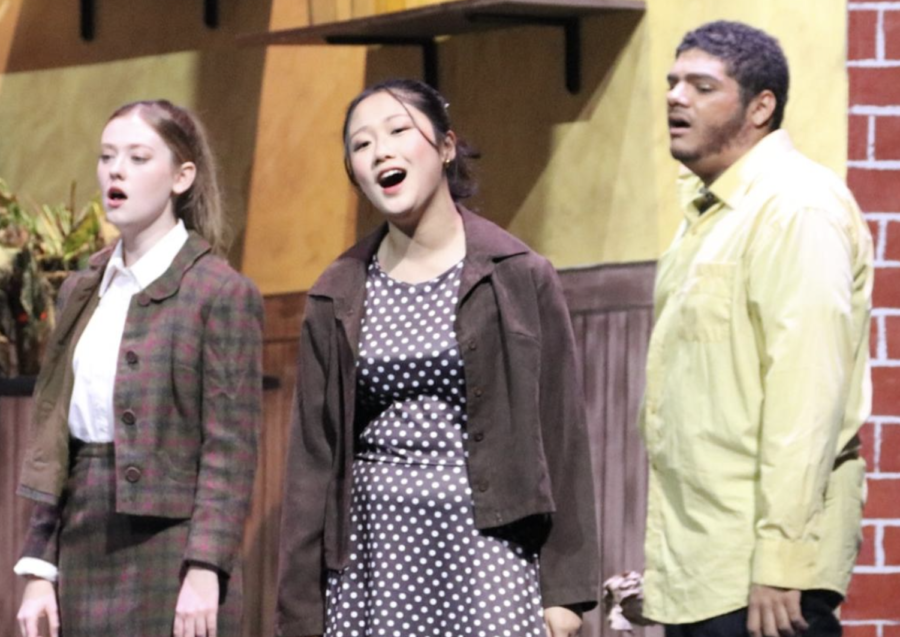 Freshman Momoka Miyazaki (middle) sings with the chorus during the fall musical production of "Little Shop of Horrors."