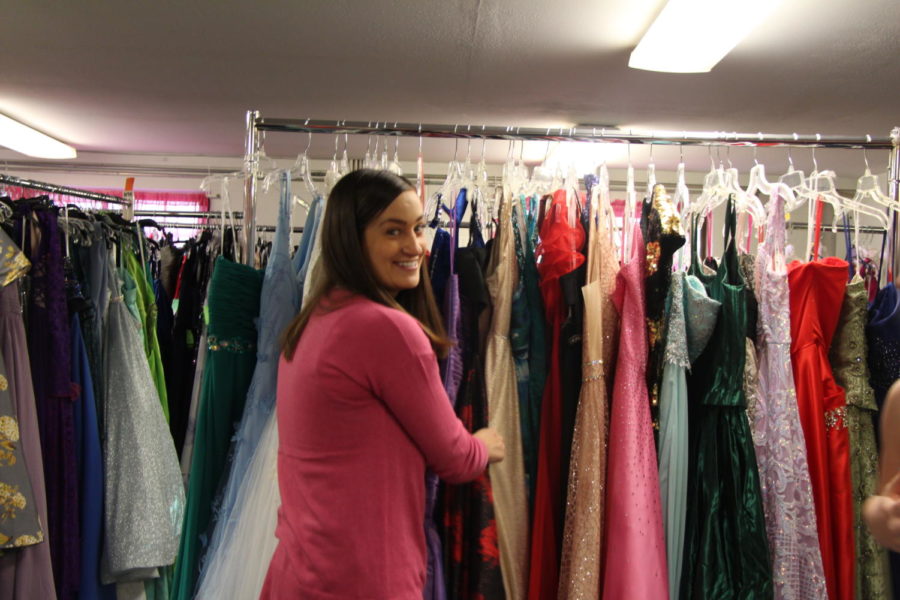 Picking out a dress, Abby Wilson looks through the “glam rack.” The glam rack is a rack of dresses that are unique, with different kinds of patterns, colors, and designs. Usually, non-traditional prom dresses go here.