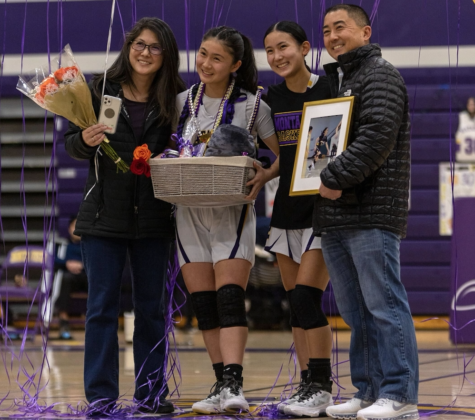 Emi and Miya Kosakura pose for a photo with their parents on senior night. 