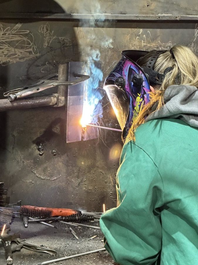 Junior Eliza Ross welds in the booth during her welding class through the LRCC.