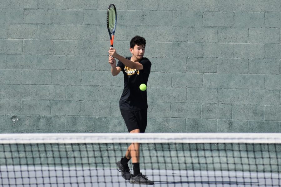 Senior Owen Taylor swings at the ball during practice on Monday, March 13, on the Sunny Hills tennis court.