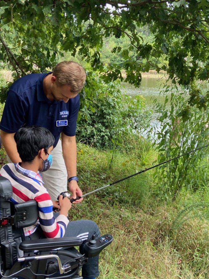 Sophomore Shaik fishing with his paraprofessional Carson Hollingsworth in the woods together. 