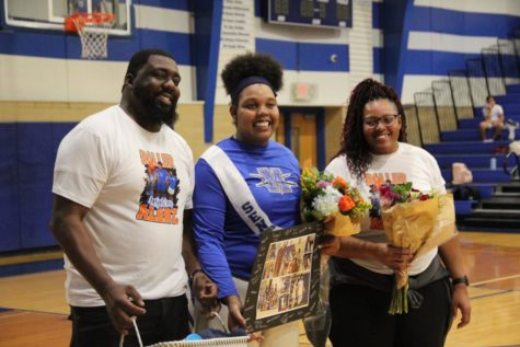 Aasja Wren poses in between her parents as the sole honoree of the basketball team on Senior Night on Feb. 13.