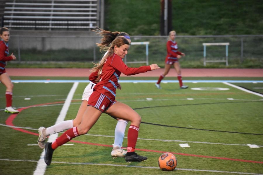 Lunging+for+the+ball%2C+senior+Julia+Liguore+looks+for+a+pass.+Liguore+was+a+starter+and+team+captain+of+the+varsity+soccer+team.+%E2%80%9C%5BMy+favorite+thing+about%5D+high+school+soccer+is+getting+to+play+in+a+stadium%2C+getting+%5Bmy%5D+name+called+out+and+running+out+through+the+%5Bplayer%5D+tunnel%2C%E2%80%9D+Liguore+said.