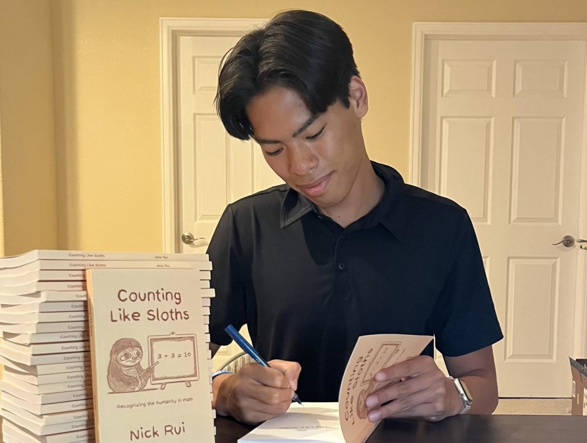 Senior Nick Rui signs copies of his new book, Counting Like Sloths, to give to family friends. The book, completely designed, written, and published by Rui, came out on Aug. 8, 2023. He went in-depth into basic structures of math, along with their historical and anthropological roots.