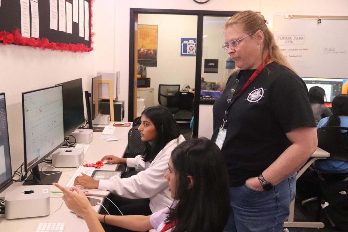 Coppell High School Round-Up yearbook adviser Katrina Hester selects photos taken by juniors Zaara Habeeb and Raashi Kalyani on Friday. Hester previously taught English for the past three years at Plano West High School,  and the 2023-24 school year is her first year advising yearbook at CHS.