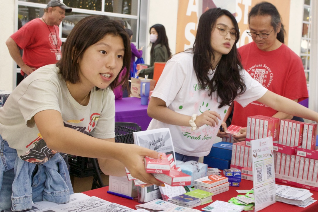 Volunteer and sophomore Nollie Chen passes out Pocky snacks to festival attendees. “It’s important for these cultural events that bring people together to have food, not just as an incentive to come together, but as something to bond over,” Chen said. “For a lot of people, food is culture, and it’s what brings people together.”