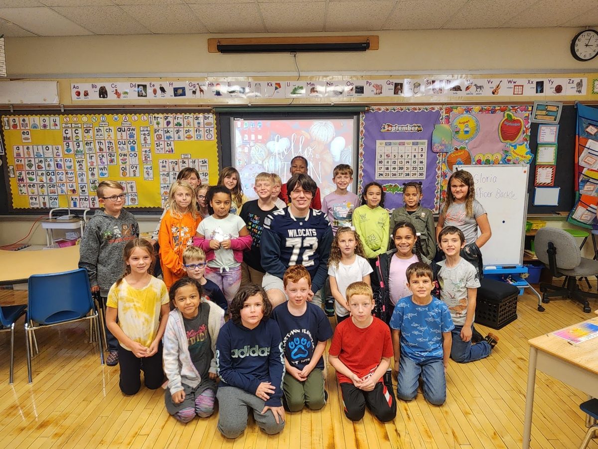 Keller+Spera+and+elementary+students+smile+for+the+camera+before+a+Friday+football+game.