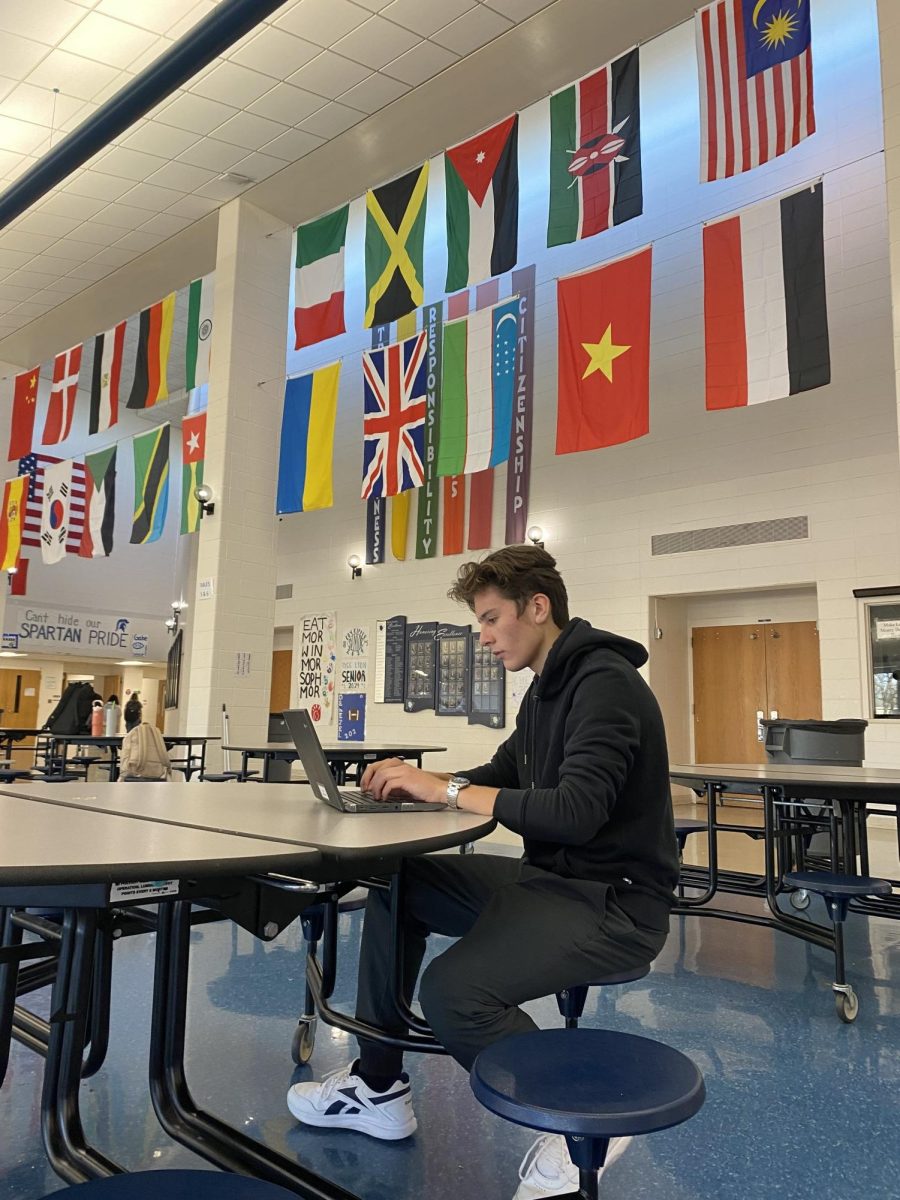 Junior+Andres+Bravo+Garza+works+on+his+assignments+under+30+flags+in+the+PVHS+cafeteria+that+represent+the+nationalities+of+international+PV+students.