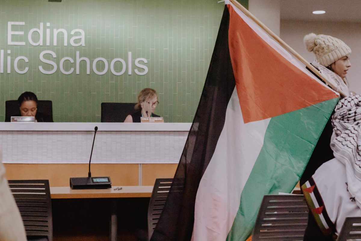 Woman+carries+Palestine+flag+while+finding+a+seat+before+the+School+Board+meeting.