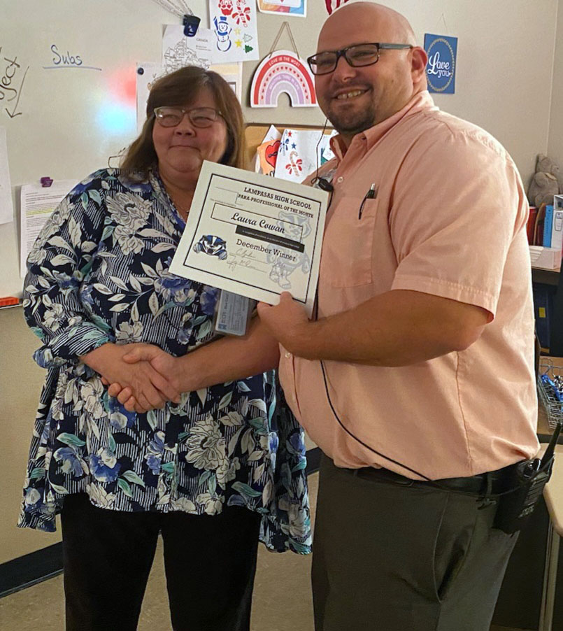 Laura Cowan receives the Paraprofessional of the Month award from assistant principal Ryan Race for Dec. 2022.  