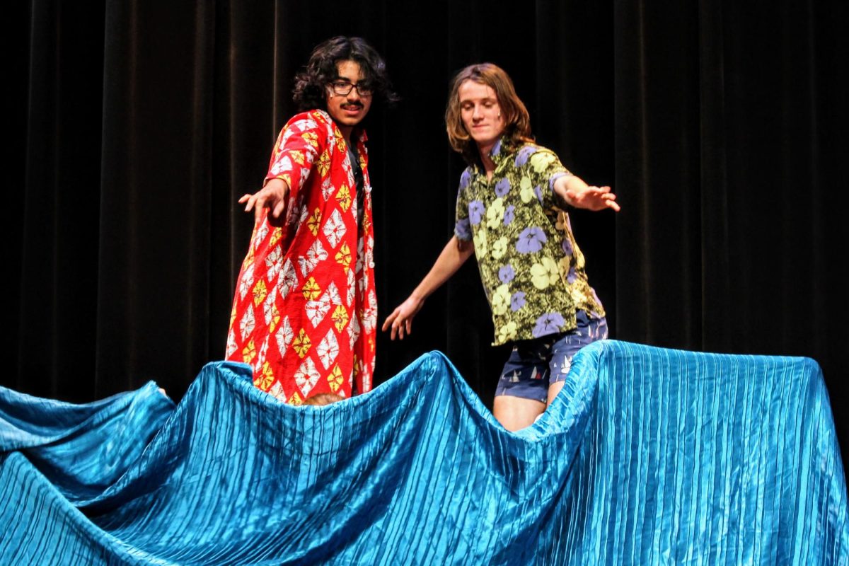Students+from+advanced+drama%2C+acting+as+rival+surfers%2C+coast+the+waves+onstage.