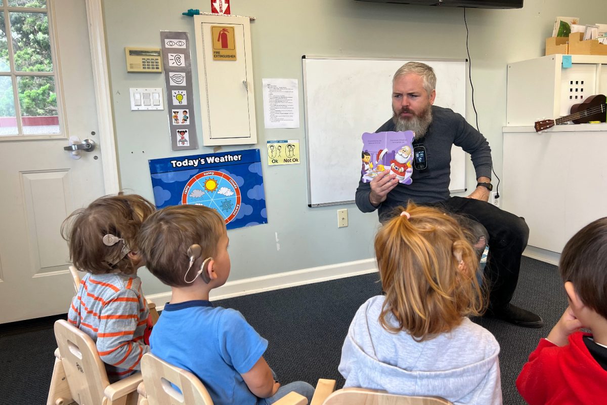 Teacher Matt reads a book to deaf children in the WCC to improve their reading, speaking, and listening skills. This is similar to Ben Rhazis experience in the WCC which helped him with writing, listening, and speaking.