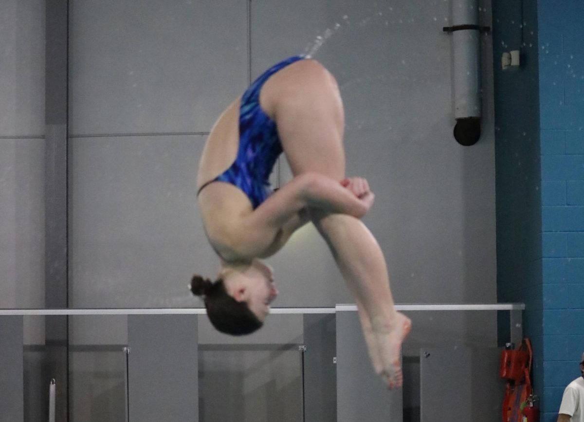 Coppell sophomore Emery Darrow attempts a reverse pike dive at Coppell YMCA on Jan. 24. As Coppell dive team captain, Darrow has broken several school records and consistently places in competition. 
