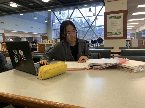 Grace Dai, sophomore, works on homework in the library. After overexerting herself to prepare for tennis tryouts, Dai said she now tries to use stress as a motivator to get things done.