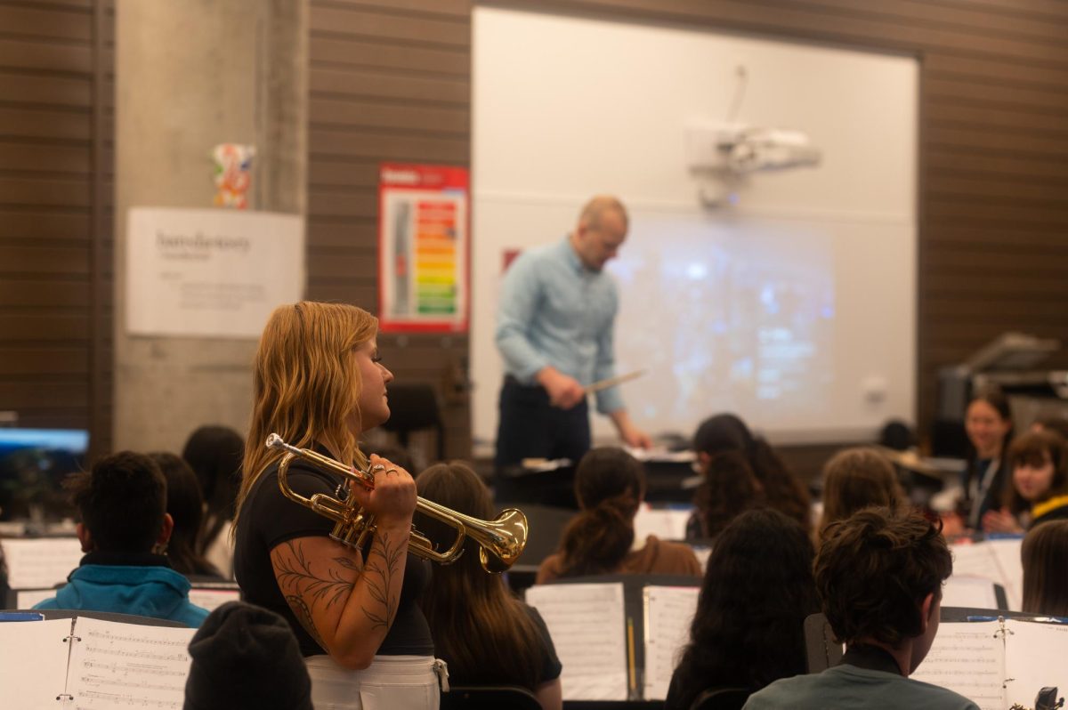 During+a+band+class%2C+co-teacher+Abby+Kott+assists+a+student+with+a+trumpet+while+co-teacher+Ryan+Hudec+directs+from+the+podium.+The+benefits+of+co-teaching+practices+are+exemplified+in+Lab%E2%80%99s+music+classes%2C+as+music+faculty+create+strong+engagement+and+introduce+students+to+numerous+perspectives.