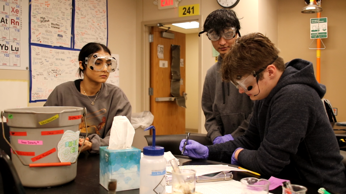 In science teacher Craig Widemans 1st Hour Organic Chemistry class, seniors Maya Walden, Vyom Tripathi, and Josh Lanzotti complete a lab near the Sneeze Bucket. While the goal of the bucket is to reduce sneezing, students have their own competitions to try and get away with sneezing in class.