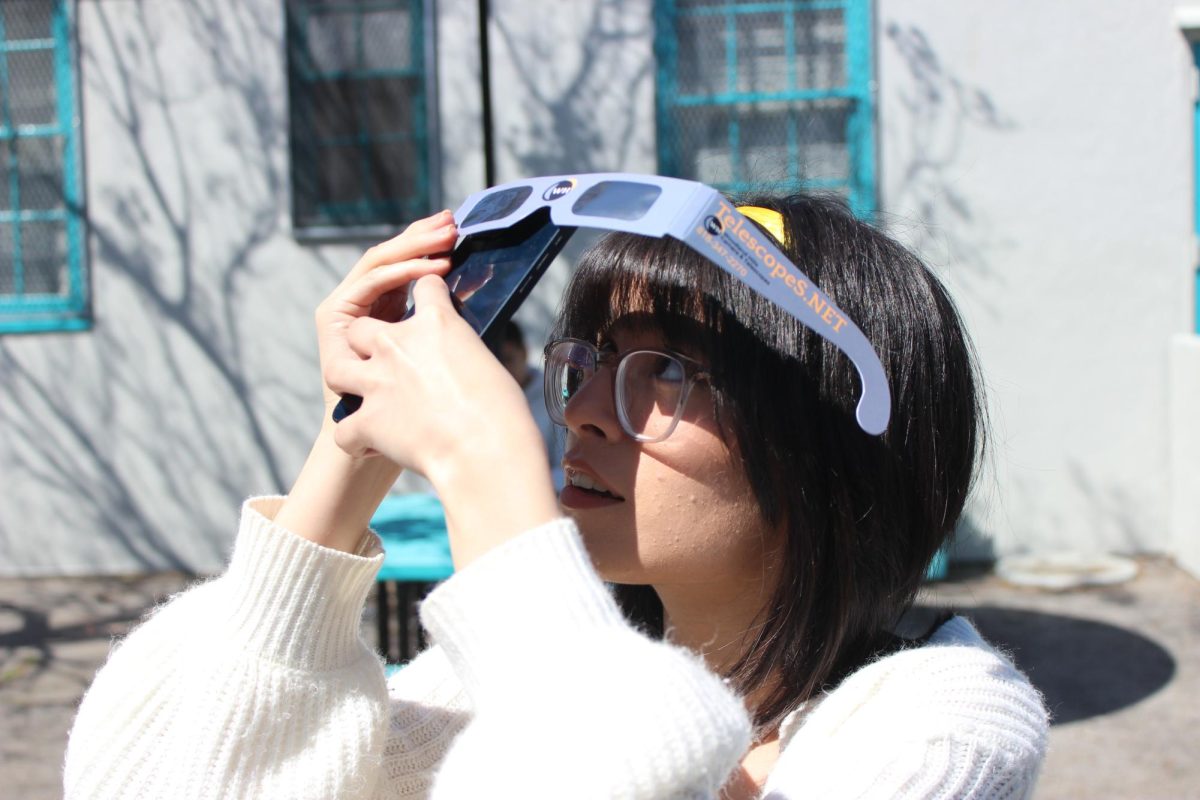 Junior+Genesis+Cuellar-Figueroa+takes+a+picture+of+the+April+8+eclipse.+By+using+the+special+eclipse+sunglasses%2C+she+protected+both+her+eyes+and+her+camera+lens.+