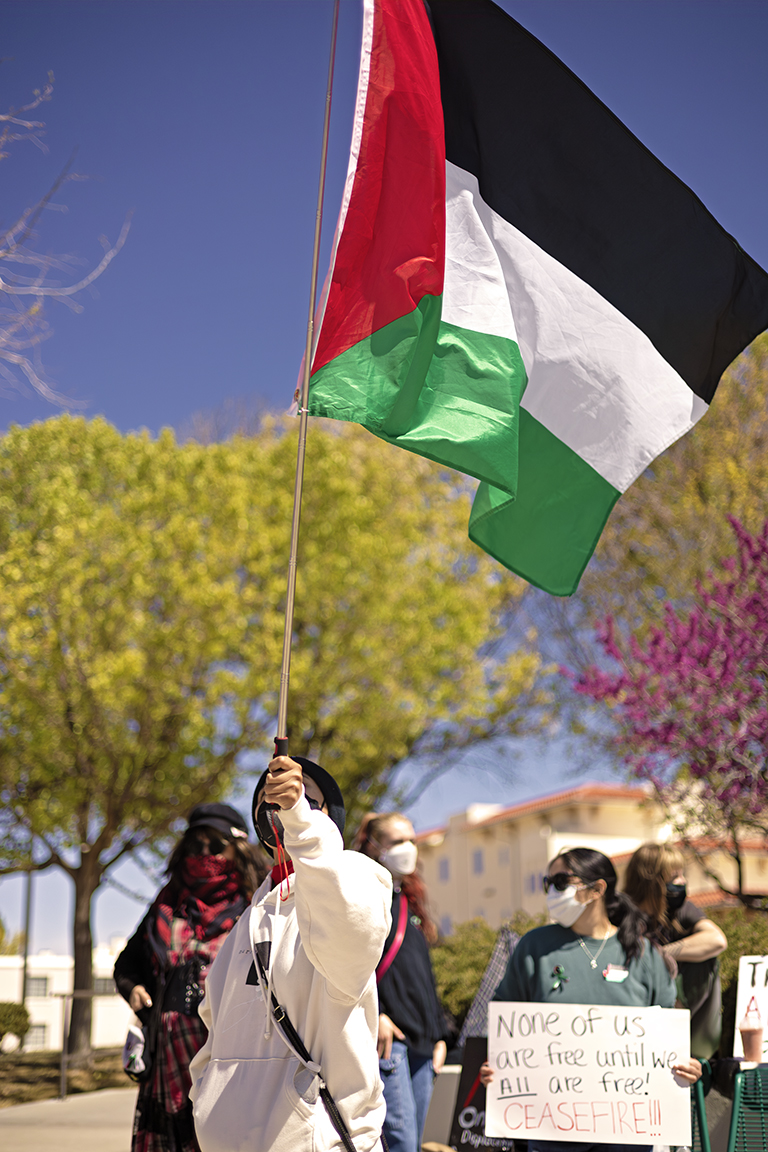 A+protestor+waves+a+Palestinian+flag+in+front+of+Corbett+Center+Student+Union.+March+28%2C+2024.