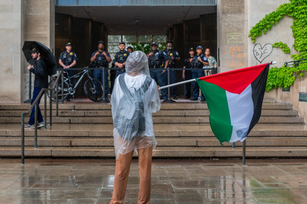 On+May+2%2C+the+fourth+day+of+the+encampment%2C+a+demonstrator+stands+in+front+of+a+group+of+police+waving+a+Palestinian+flag.+On+Monday%2C+April+29%2C+UChicago+United+for+Palestine+launched+an+encampment+on+the+University+of+Chicago%E2%80%99s+Main+Quad+to+stand+in+solidarity+with+the+Palestinian+people.+The+encampment+and+pro-Palestinian+protests+continued+for+days.