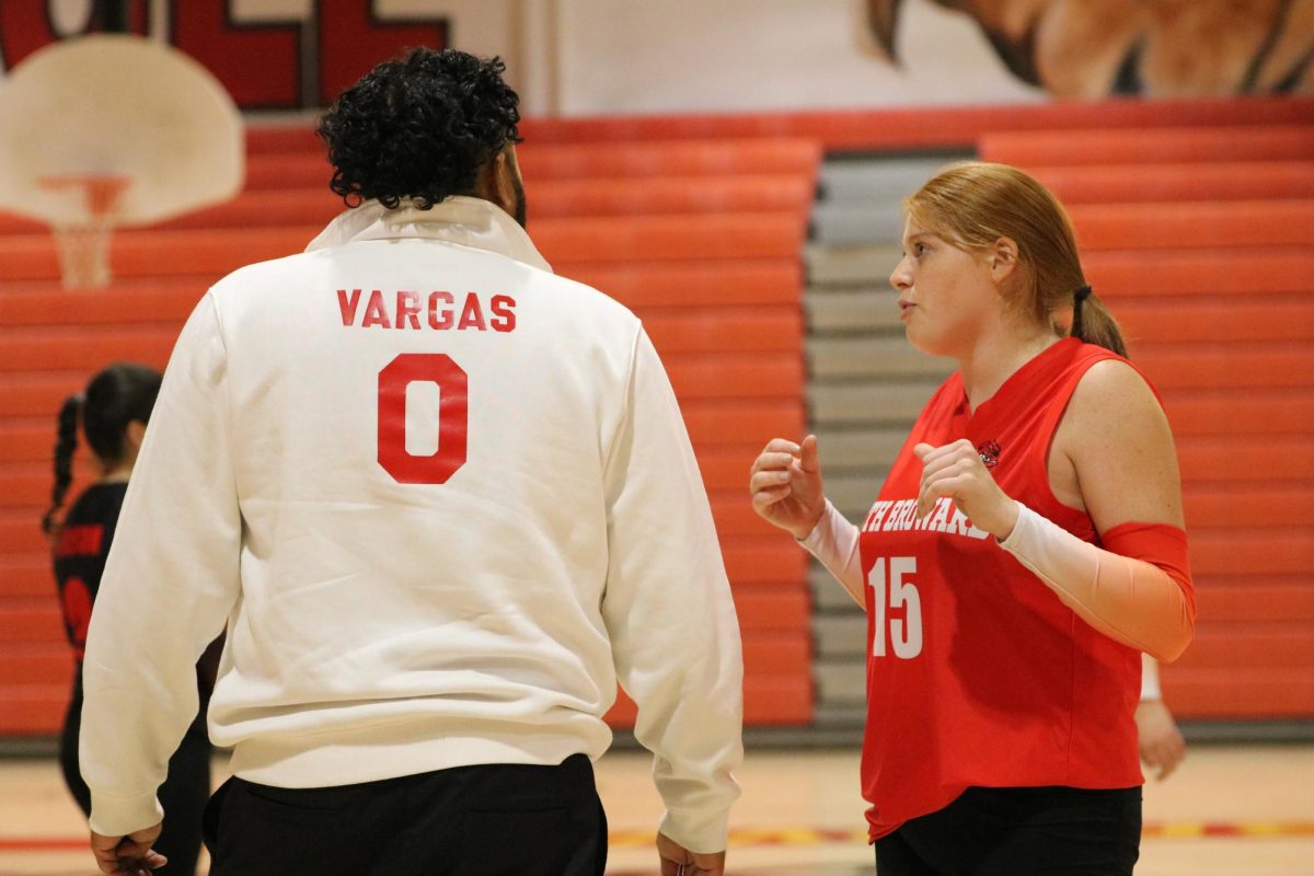 SBHS senior Casey Carlson shows what being a captain is all about while she discusses the Lady Bulldogs plan to defeat the Mustangs with her coach, Marc Vargas.
