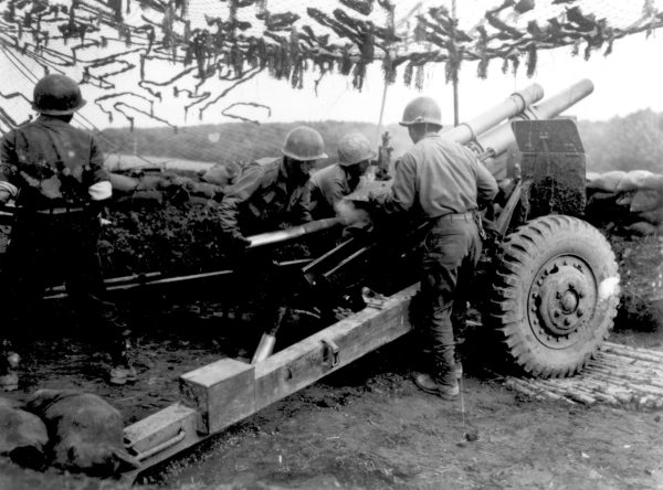 The 522nd Field Artillery Battalion firing shells at the enemy with a
105 milimeter gun. Photo by 522nd Committee.