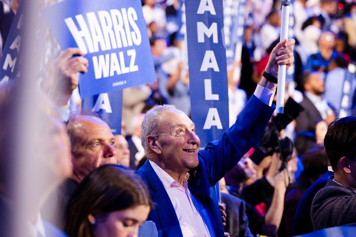 Sen. Chuck Schumer (D-N.Y.) holds a "Kamala" sign high during the fourth night of the Democratic National Convention in Chicago. Schumer is an PLEO delegate due to his senate seat.