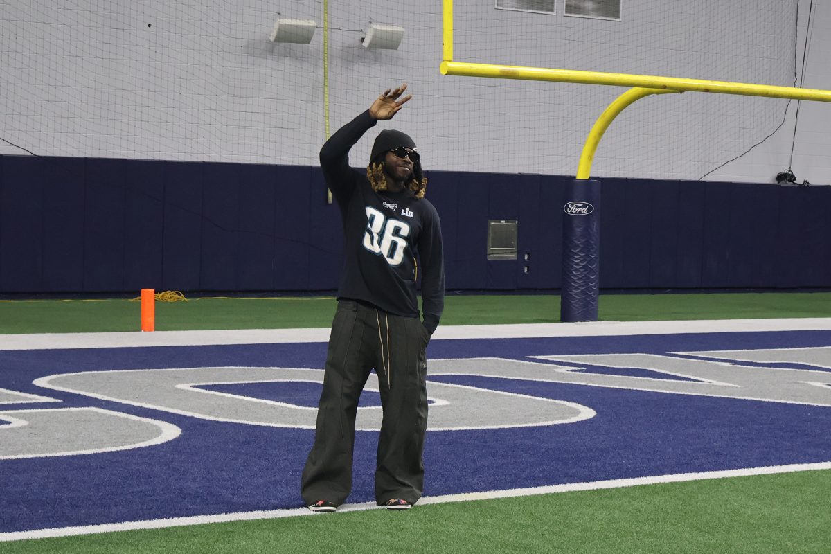 The first Frisco ISD football player to win a Super Bowl, former Redhawks star Jay Ajayi waves to the crowd at the Ford Center after being introduced as a member of the Class of 2025 FISD Hall of Honor.