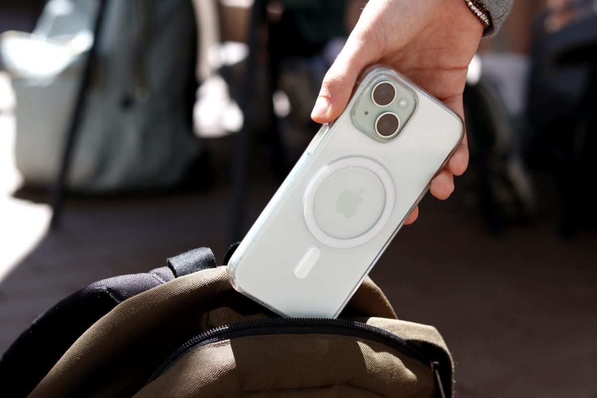 Dropping her phone into her backpack for the day, a student follows the rules of the new tech-free phone policy. Upper School Director Maggie Cenan said the new policy aligns with Archer's mission to best serve students. 