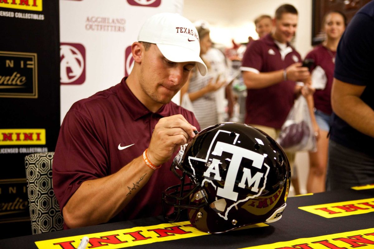 Johnny Manziel signs a Texas A&M football helmet at an Aggieland Outfitters event (file photo)